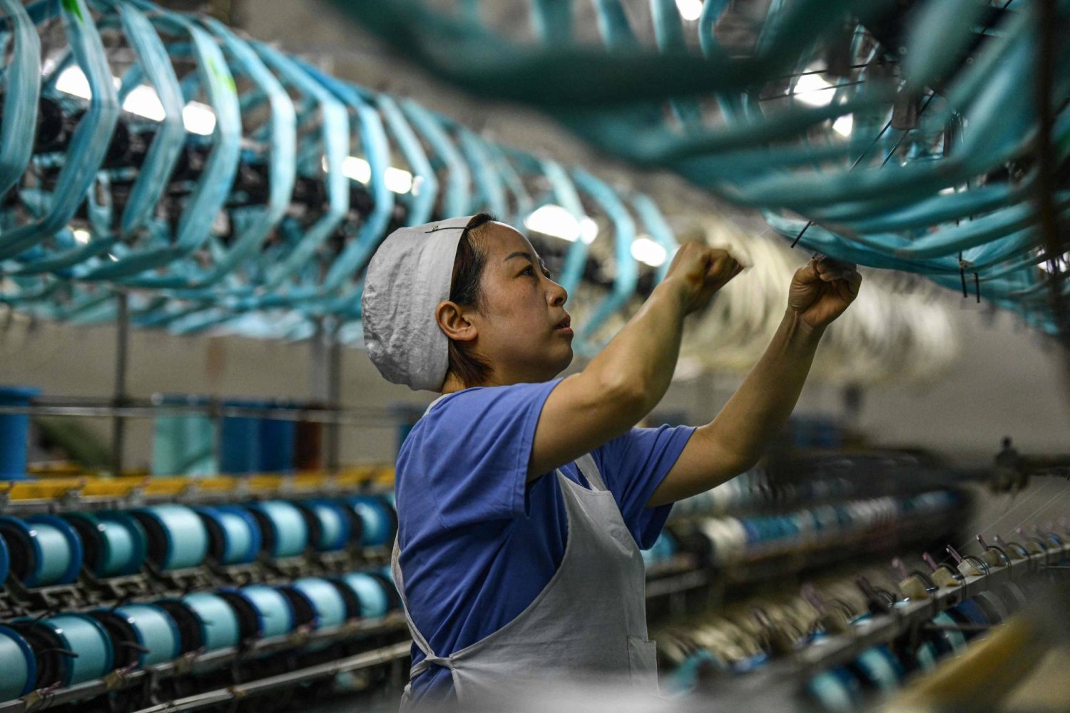 عاملة في مصنع للنسيج في فويانغ بمقاطعة آنهوي شرق الصين (أ.ف.ب)