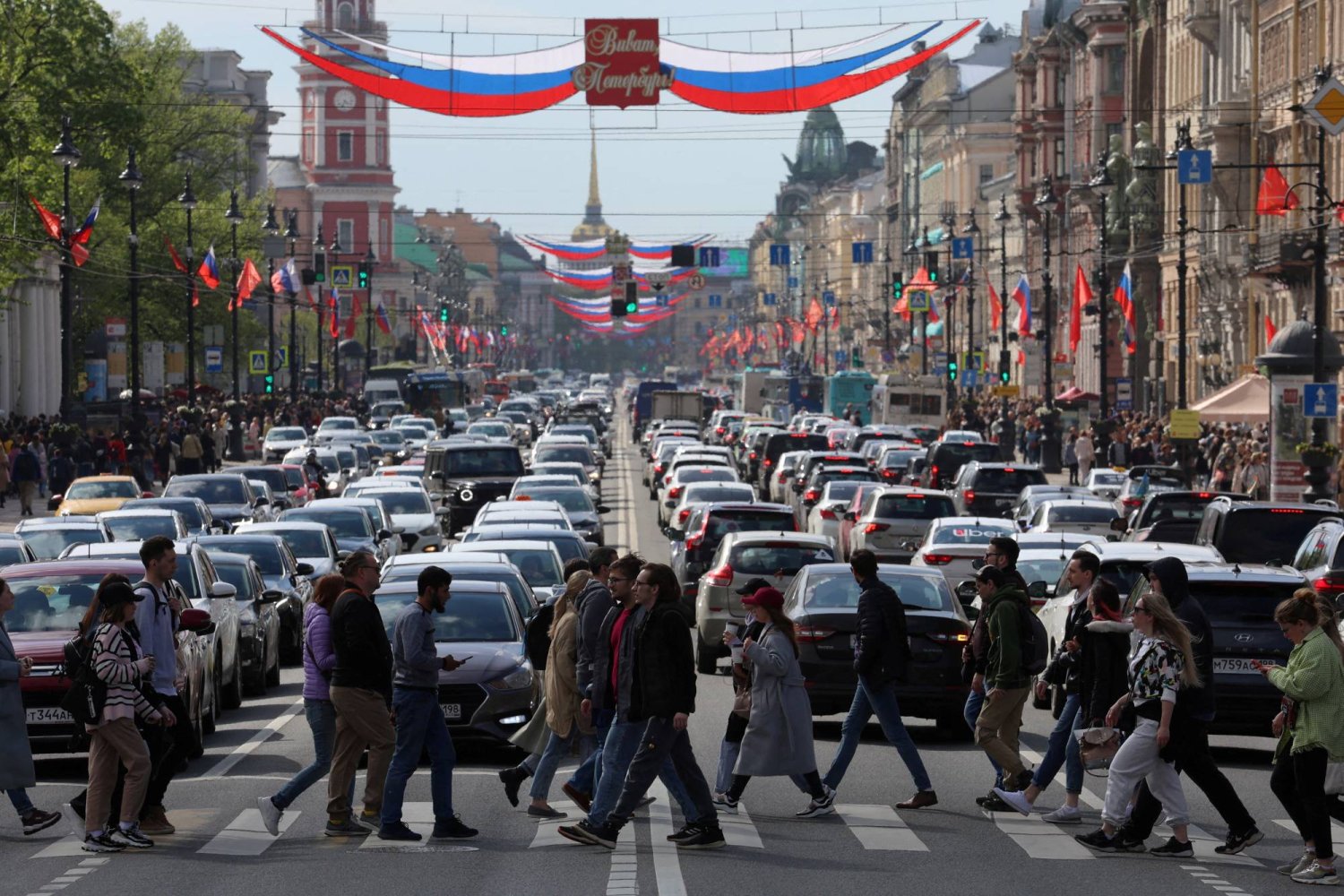 مشاة يسيرون عبر شارع نيفسكي في وسط سانت بطرسبرغ - روسيا (رويترز)