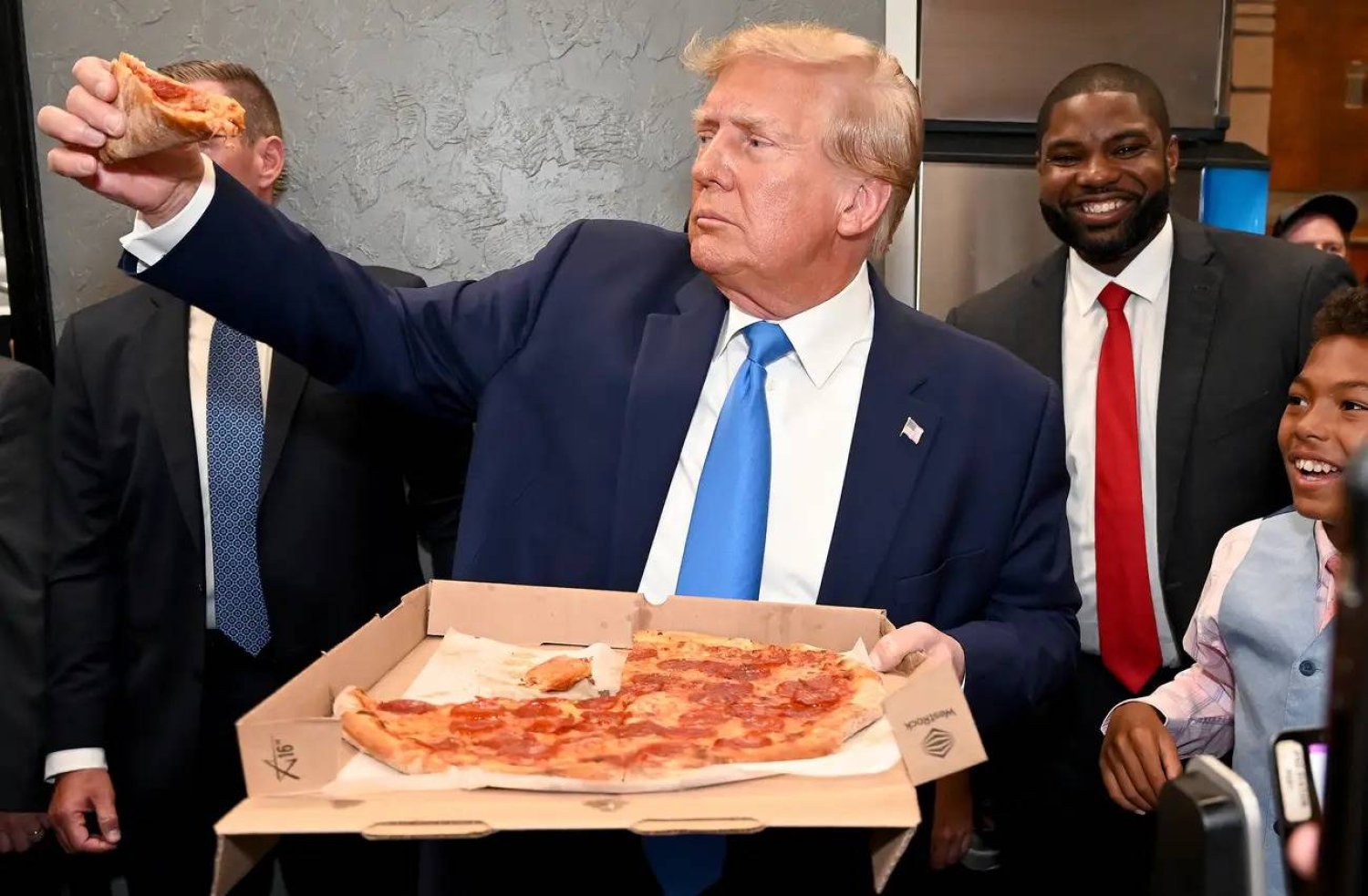 ترمب يتناول البيتزا خلال إحدى جولاته الانتخابية في ولاية فلوريدا العام الماضي (أ.ب)