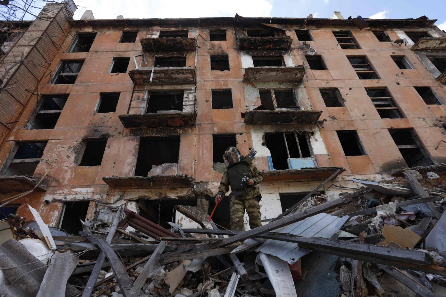 خبير متفجرات روسي يتفقد مبنى مدمراً في ماريوبول في أوكرانيا التي تسيطر عليها روسيا (أ.ف.ب)