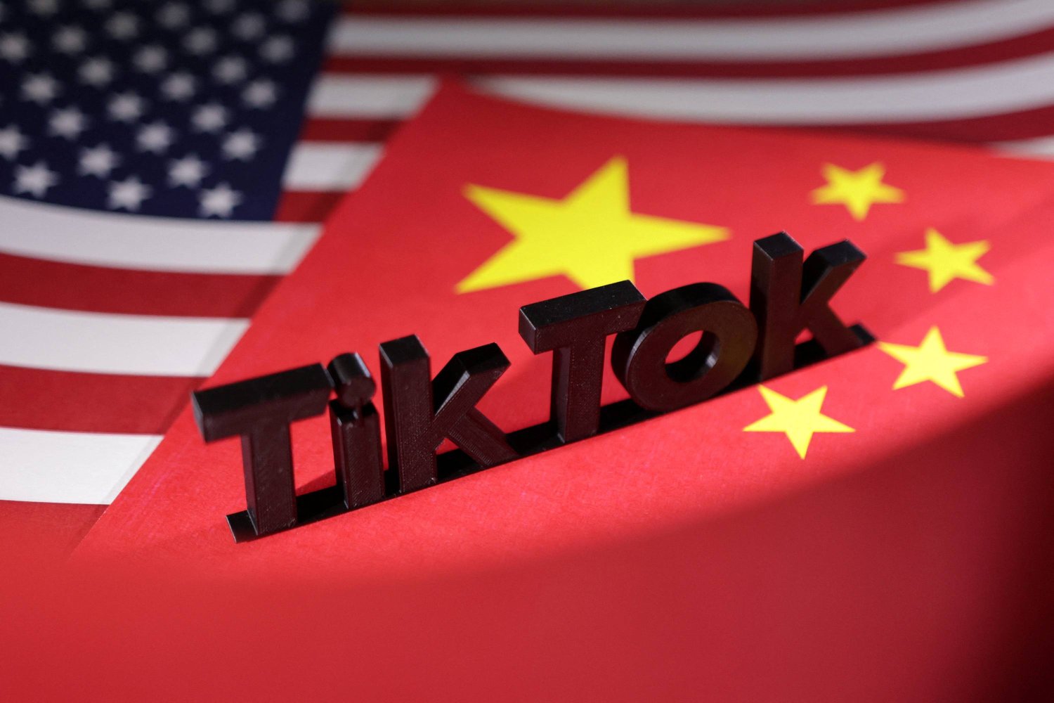 شعار تطبيق «تيك توك» فوق علمي الصين والولايات المتحدة (رويترز)