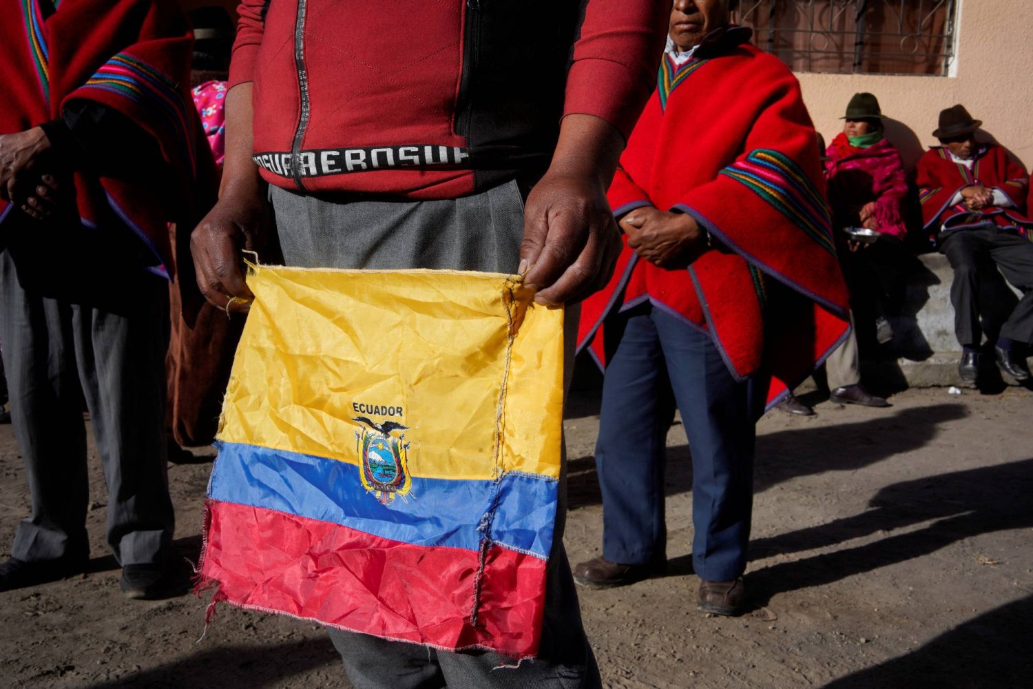 رجل يحمل علم الإكوادور (رويترز)