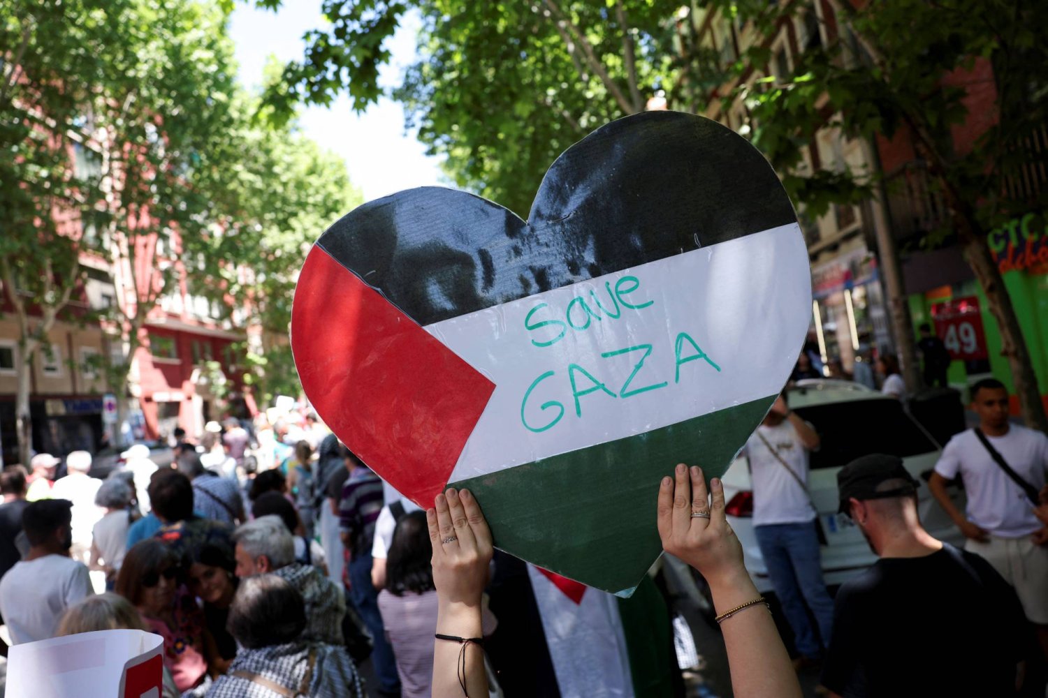متظاهر يحمل لافتة بينما يدعو الناس إلى وقف إطلاق النار في غزة خلال مسيرة لإحياء ذكرى يوم النكبة في مدريد - إسبانيا (رويترز)