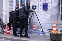 رجلا شرطة بجوار جثة القتيل ضحية إطلاق النار في دوسلدروف (د.ب.أ)